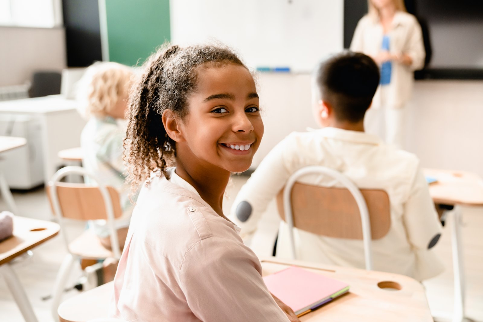 African-american young smart schoolgirl pupil student attending school lesson class listening to the teacher. Back to school. New academic year semester.